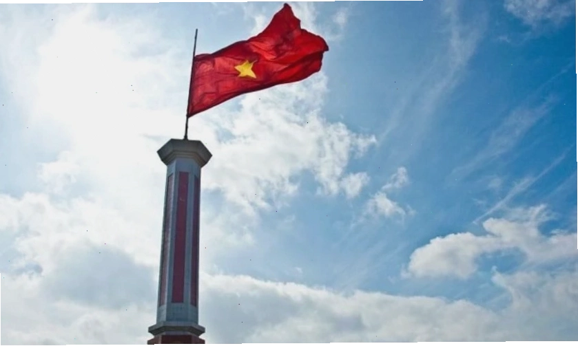 Hình nền lá cờ Việt Nam tung bay trên nền trời xanh mây trắng