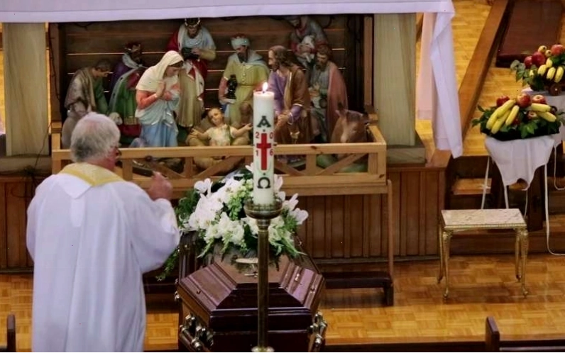 Thập giá, Chúa Giêsu, nến và hoa huệ trắng trong đám tang công giáo